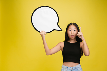 Image showing Portrait of young asian girl isolated on yellow studio background