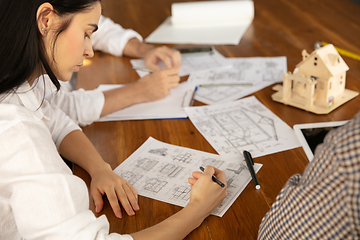 Image showing Male architect-engineer presents project of future house for young family.