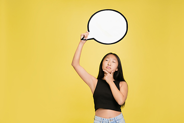 Image showing Portrait of young asian girl isolated on yellow studio background