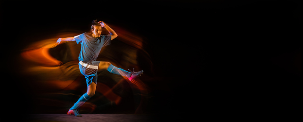 Image showing Football or soccer player on black background in mixed light, fire shadows