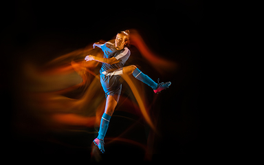 Image showing Football or soccer player on black background in mixed light, fire shadows