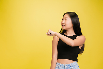 Image showing Portrait of young asian girl isolated on yellow studio background