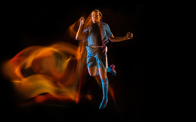 Image showing Football or soccer player on black background in mixed light, fire shadows