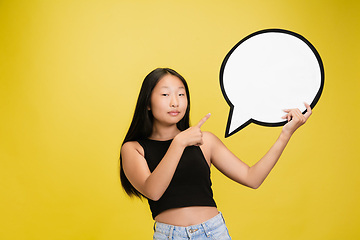 Image showing Portrait of young asian girl isolated on yellow studio background