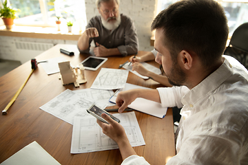 Image showing Male architect-engineer presents project of future house for young family.