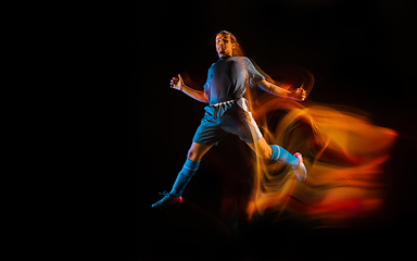 Image showing Football or soccer player on black background in mixed light, fire shadows