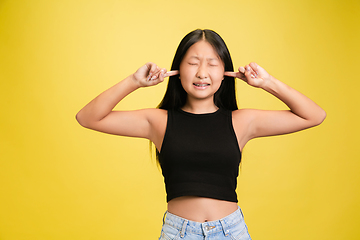 Image showing Portrait of young asian girl isolated on yellow studio background
