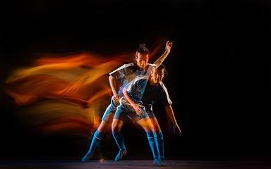 Image showing Football or soccer player on black background in mixed light, fire shadows