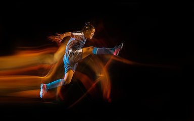 Image showing Football or soccer player on black background in mixed light, fire shadows