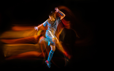 Image showing Football or soccer player on black background in mixed light, fire shadows