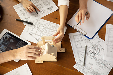 Image showing Male architect-engineer presents project of future house for young family.