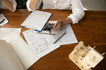 Image showing Male architect-engineer presents project of future house for young family.