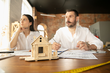 Image showing Young family listening to male architect-engineer presents project of future house