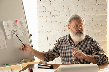 Image showing Male architect-engineer presents project of future house for young family.