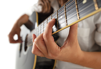 Image showing Close up of guitarist hand playing guitar, copyspace, macro shot