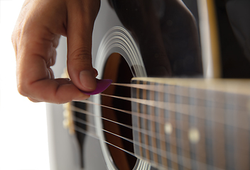 Image showing Close up of guitarist hand playing guitar, copyspace, macro shot