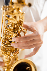 Image showing Close up woman playing saxophone isolated on white studio background