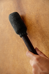 Image showing A close up of hands playing the tambourine, percussion on white studio background