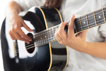 Image showing Close up of guitarist hand playing guitar, copyspace, macro shot