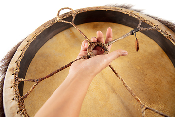 Image showing A close up of hands playing the tambourine, percussion on white studio background