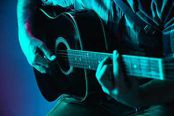 Image showing Close up of guitarist hand playing guitar, copyspace, macro shot