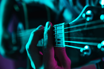 Image showing Close up of guitarist hand playing guitar, copyspace, macro shot