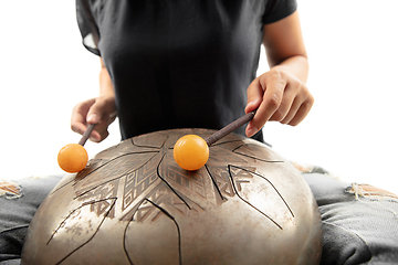 Image showing A close up of hands playing the hank drum on white studio background