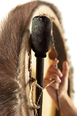 Image showing A close up of hands playing the tambourine, percussion on white studio background