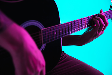 Image showing Close up of guitarist hand playing guitar, copyspace, macro shot