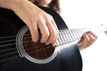 Image showing Close up of guitarist hand playing guitar, copyspace, macro shot