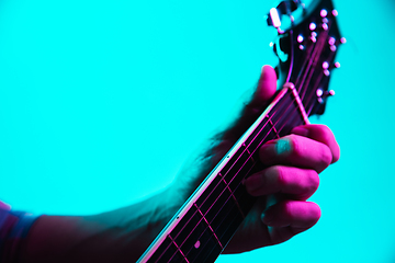 Image showing Close up of guitarist hand playing guitar, copyspace, macro shot