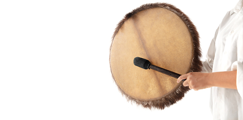 Image showing A close up of hands playing the tambourine, percussion on white studio background