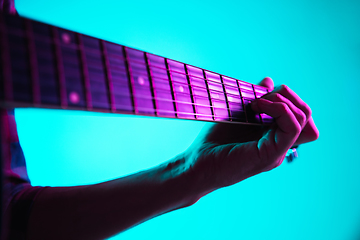 Image showing Close up of guitarist hand playing guitar, copyspace, macro shot