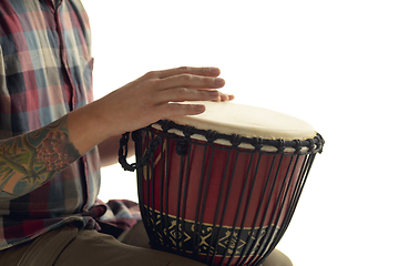 Image showing Man plays ethnic drum darbuka percussion, close up musician isolated on white studio background