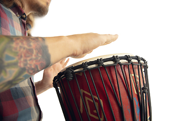 Image showing Man plays ethnic drum darbuka percussion, close up musician isolated on white studio background