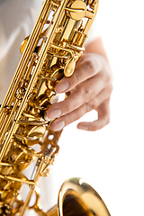 Image showing Close up woman playing saxophone isolated on white studio background