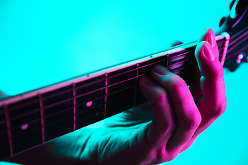 Image showing Close up of guitarist hand playing guitar, copyspace, macro shot