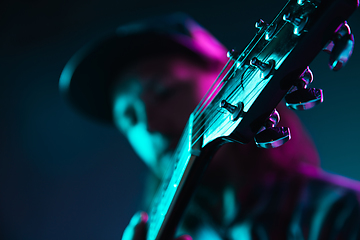 Image showing Close up of guitarist hand playing guitar, copyspace, macro shot