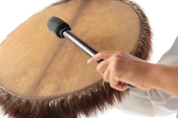 Image showing A close up of hands playing the tambourine, percussion on white studio background