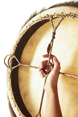 Image showing A close up of hands playing the tambourine, percussion on white studio background
