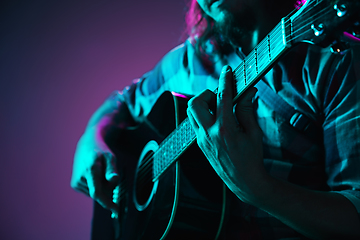 Image showing Close up of guitarist hand playing guitar, copyspace, macro shot