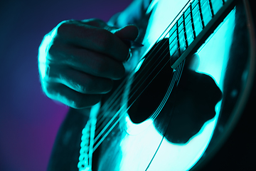 Image showing Close up of guitarist hand playing guitar, copyspace, macro shot