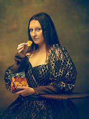 Image showing Young woman as Mona Lisa on dark background. Retro style, comparison of eras concept.