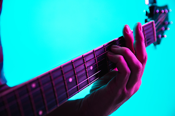 Image showing Close up of guitarist hand playing guitar, copyspace, macro shot