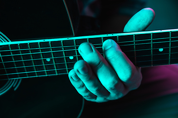 Image showing Close up of guitarist hand playing guitar, copyspace, macro shot