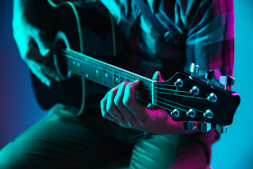 Image showing Close up of guitarist hand playing guitar, copyspace, macro shot