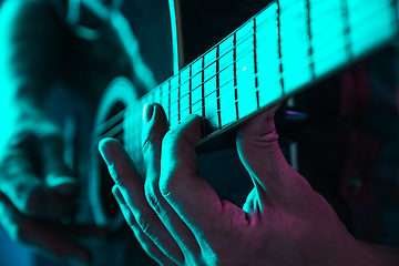 Image showing Close up of guitarist hand playing guitar, copyspace, macro shot