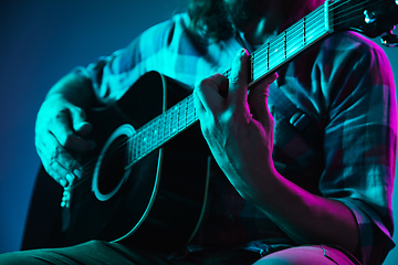 Image showing Close up of guitarist hand playing guitar, copyspace, macro shot