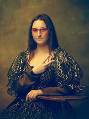 Image showing Young woman as Mona Lisa on dark background. Retro style, comparison of eras concept.