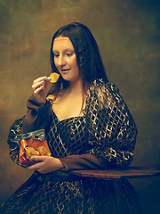 Image showing Young woman as Mona Lisa on dark background. Retro style, comparison of eras concept.